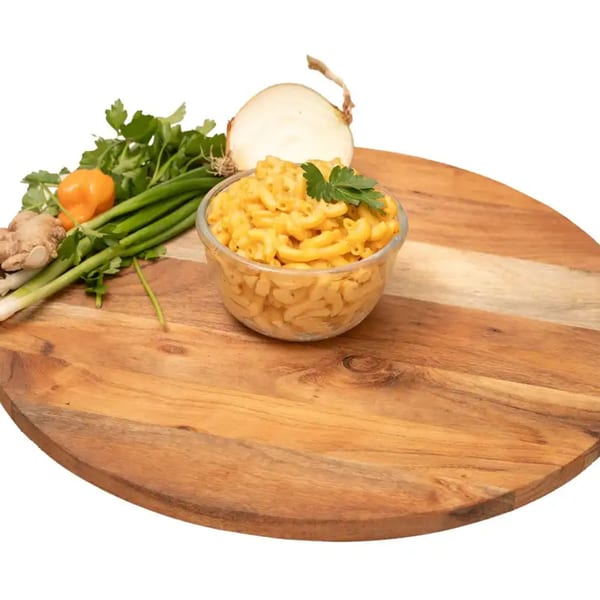A bowl of Caribbean mac and cheese with fresh herbs, ginger, onion, and a habanero pepper.