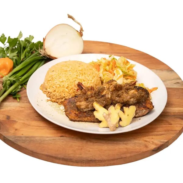Caribbean jerk shrimp and chicken with rice, coleslaw, and ginger slices on a white plate.
